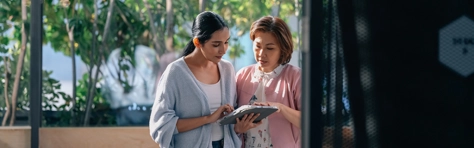 Zwei Frauen schauen auf ein Tablet